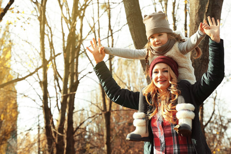 Mother and daughter playing in beautiful autumn parkの写真素材