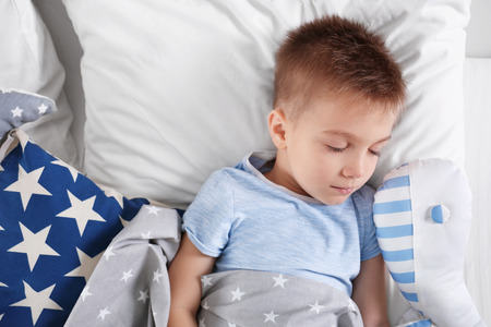 Little boy sleeping in bedの写真素材