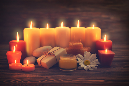 Beautiful composition of alight candles and honey treatments on wooden tableの写真素材
