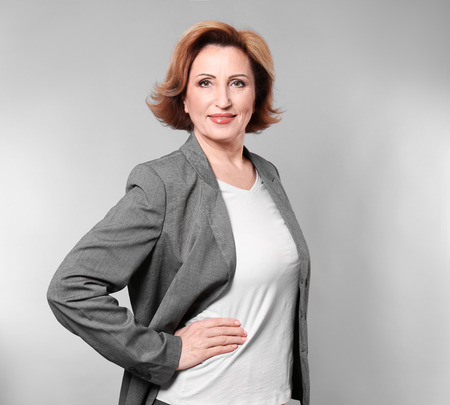 Portrait of gorgeous senior woman on colour backgroundの写真素材