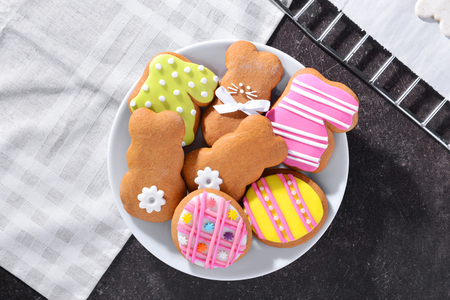 Plate with colourful Easter cookies on kitchen table