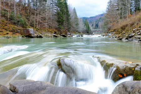Mountain river flowing through autumn forest