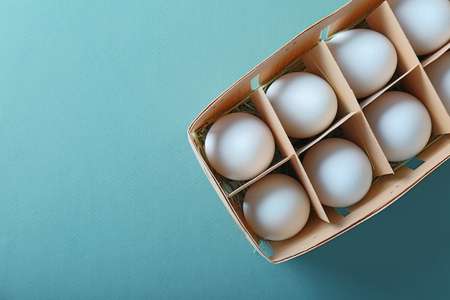 Raw eggs in package on green backgroundの写真素材