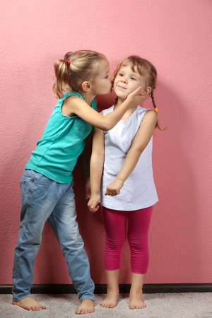 Adorable little girls on pink backgroundの写真素材