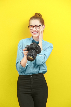 Beautiful young photographer on color backgroundの写真素材