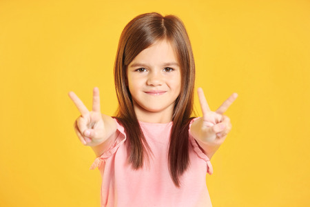 Attractive little girl on yellow backgroundの写真素材