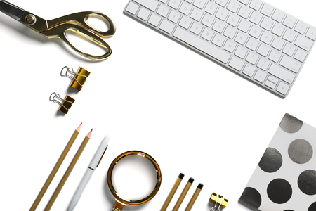 Flat lay of golden stationery with keyboard on white backgroundの写真素材