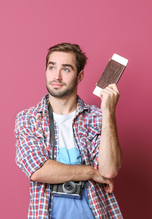 Man traveler with passport and ticket on color backgroundの写真素材