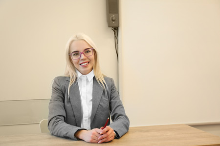 Beautiful school teacher sitting in the classroomの写真素材