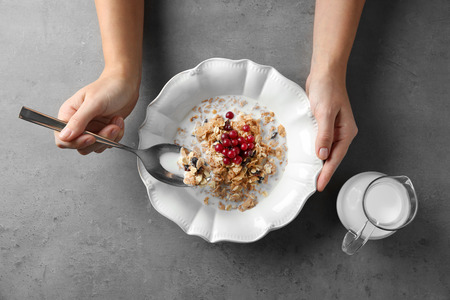 Female hands holding bowl with healthy breakfast, closeupの写真素材