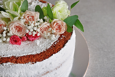 Delicious wedding cake decorated with flowers on grey tableの写真素材