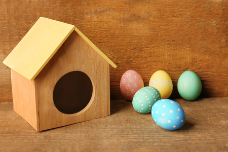Colorful Easter eggs and little house on wooden backgroundの写真素材