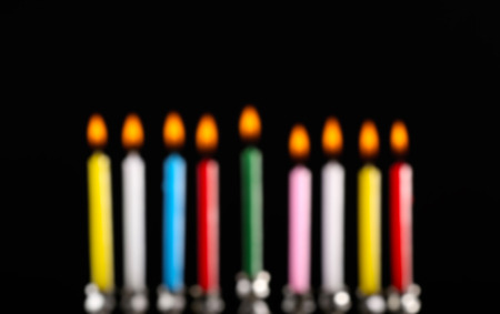 Blurred view of menorah with candles for Hanukkah on black backgroundの写真素材