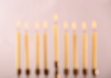 Blurred view of menorah with candles for Hanukkah on light background, close upの写真素材
