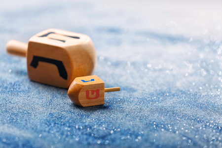 Wooden dreidels for Hanukkah on light sparkling backgroundの写真素材