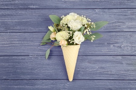Waffle cone with composition of beautiful flowers on gray backgroundの写真素材
