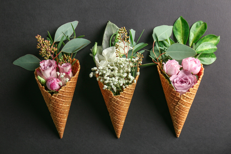 Composition of waffle cones with flowers and branches on dark backgroundの写真素材