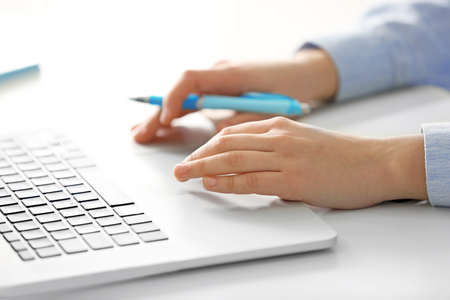 Young woman working in office with laptop, closeupの写真素材