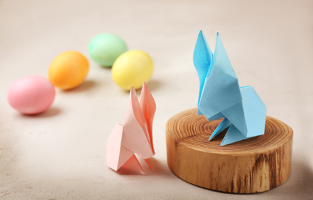 Origami paper bunnies and Easter eggs on light backgroundの写真素材