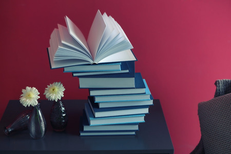 Stack of books on color wall background