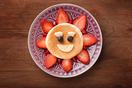 Plate with creative homemade pancake on wooden tableの写真素材