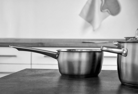 Set of metal pans on table in kitchenの写真素材