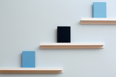 Shelf with new books on light wall backgroundの写真素材