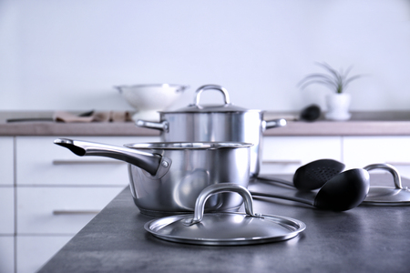 Set of metal pans on table in kitchenの写真素材
