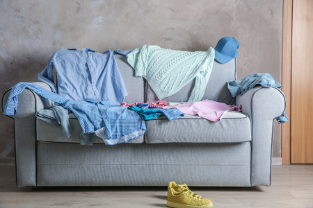 Pile of clothes on cozy couchの写真素材