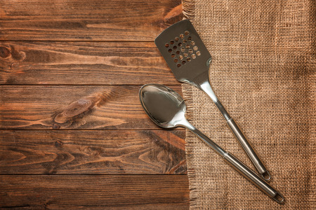 Metal kitchen utensils on wooden tableの写真素材