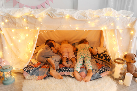 Cute little children sleeping in hovel at homeの写真素材