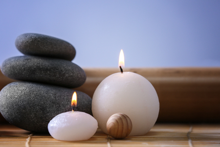 Spa stones with candles on color backgroundの写真素材