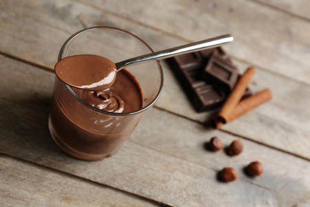Chocolate mousse in glass with spoon on wooden backgroundの写真素材