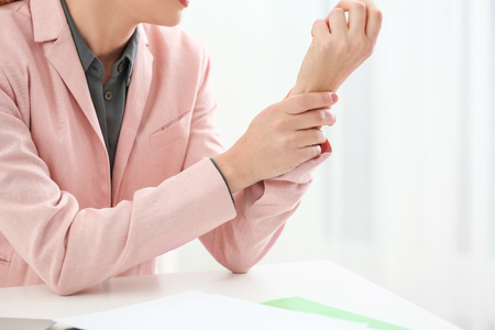 Beautiful woman suffering from pain in wrist, closeupの写真素材