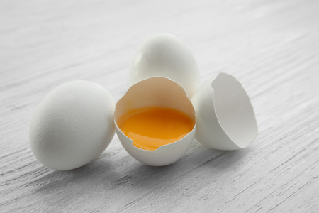 Raw eggs with yolk on wooden backgroundの写真素材