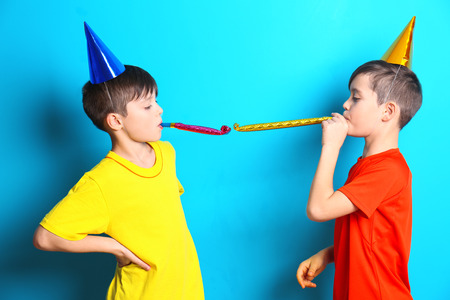 Cute birthday boys with party hats on blue backgroundの写真素材