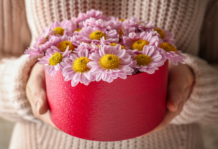 Woman holding beautiful flowers in gift box, closeupの写真素材