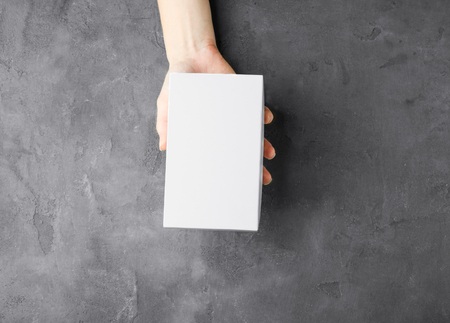 Female hand with white box on grey textured background