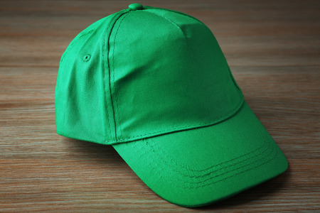 Blank green baseball cap on wooden backgroundの写真素材