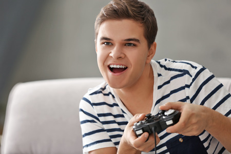 Teenager playing videogame at homeの写真素材