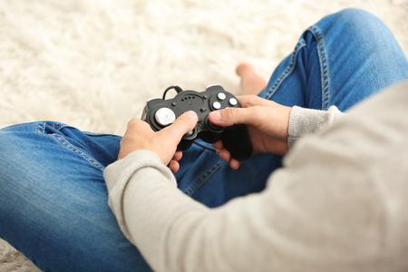 Teenager playing videogame at home, closeup
