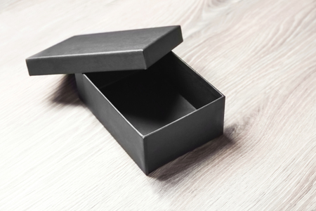 Black empty box on wooden background