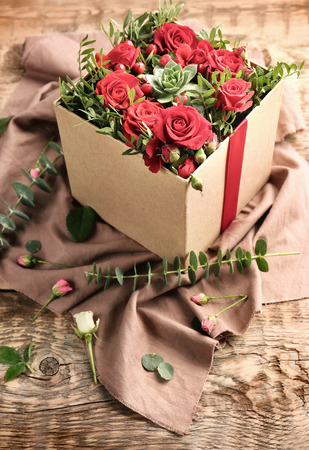 Beautiful flowers in gift box on wooden backgroundの写真素材
