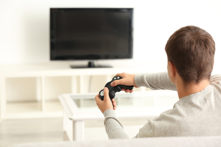 Teenager playing videogame at homeの写真素材
