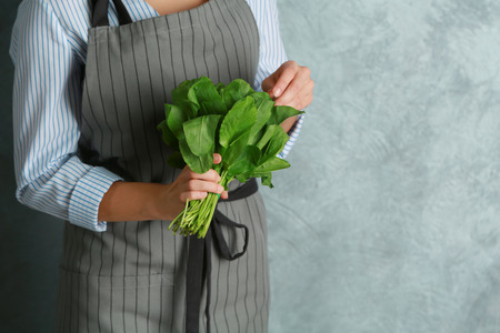 Woman in apron holding bunch of fresh herbs, closeupの写真素材
