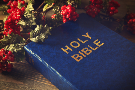 Close up view of Bible and mistletoe branch on wooden tableの写真素材