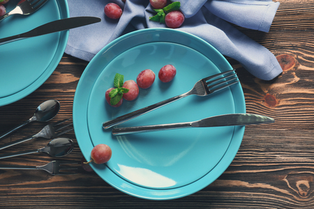 Blue plates and cutlery on wooden backgroundの写真素材