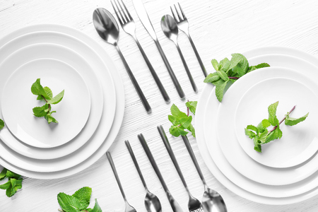 Cutlery set with plates on white wooden tableの写真素材