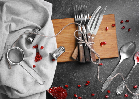 Cutlery set and garnet on gray table