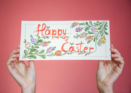Female hands holding beautiful Easter greeting card on color background